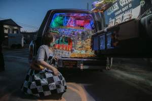 Jane Tardo peers deep inside their Haunted Hearse Phone Rollercoaster, a miniature fluorescent rollercoaster built inside a black hearse.