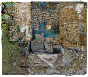 “The Slabs of my Depth” is a rectangular and textured assemblage. At the center, a partially legible photograph of a dilapidated interior space is visible, with a blue wall above beige tiles and slabs of broken concrete. Moving out from center, areas are covered with different floral and patterned laces, punctuated with textures of cement pushing through fine holes, and swashes of blue and green paint turning the composition increasingly abstract.
