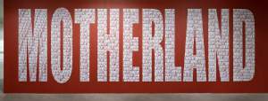 NATIVE LAND (MOTHERLAND) is a large text installation of white letters on a red background reading MOTHERLAND. The letters are formed of smaller text reading NATIVELAND.