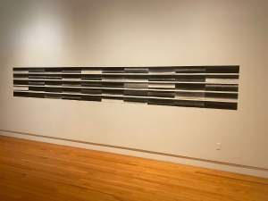 Ke Ano is a grid of prints forming four rows of abstract horizontal patterns, each row composed of six gradient blocks transitioning from light to dark shades.