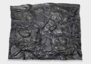 62” Topographic model is a dark gray aluminum casting of a vacuum-sealed storage bag from the artist’s baggage. Among the textured wrinkles of the back, are visible outlines of objects, including a flip-flop, and back of a picture frame.