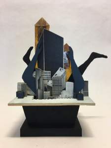 For Bruno is a sculpture on a small angular pedestal. Flat buildings and silhouettes of limbs are stacked in front of each other, creating a diorama effect.