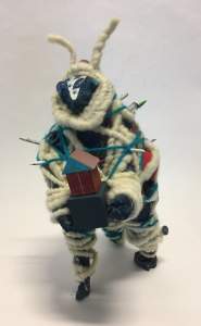 His Name is Jesse is a small bug-like figural sculpture wrapped with yarn. Antennae extend from a triangular face, and it carries a small house in its hands.