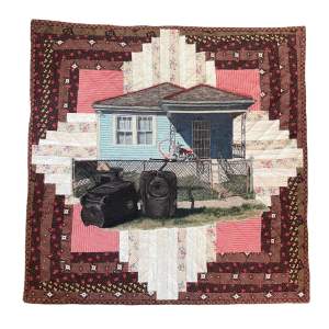 Log Cabin is a  quilted artwork depicting a small blue house with a front porch, grass lawn, and some scattered outdoor items, surrounded by a symmetrical patterned quilt border.