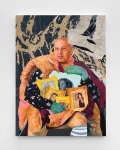 A bald man gazes seriously and  sits in a chair holding several framed portraits in his lap, encircling them with his arms, and green hands. A fluffy comforter is draped over his shoulder, and he wears a blue striped sock on one leg.