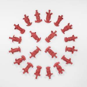 Feast Calendar (Red) is made of 20+ small red religious figurines arranged in a circular pattern on a white background. Each angel or virgin mary rests on an arch of chunky donkey teeth.
