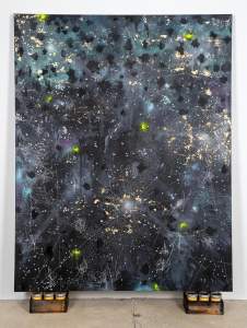 Crappie Painting: To Take A Life To Sustain A Life is a vertical a abstract painting with a dark, starry background. Features splashes of gold, green highlights, and intricate white line patterns. Stands on small wooden crates with jars of corn grits.