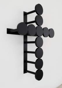 “Gravity” is a wall sculpture formed of 1:1 scale replicas of round prison visiting room stools bolted to bars. The stools are ordered in two lines to form a cross.