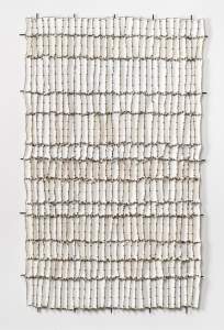Thirteen Moons is a vertical textile artwork, composed of of 13 rows of 28 irregular waxed white cloth rectangles, in rows of variable heights stitched together using metal black hog rings.