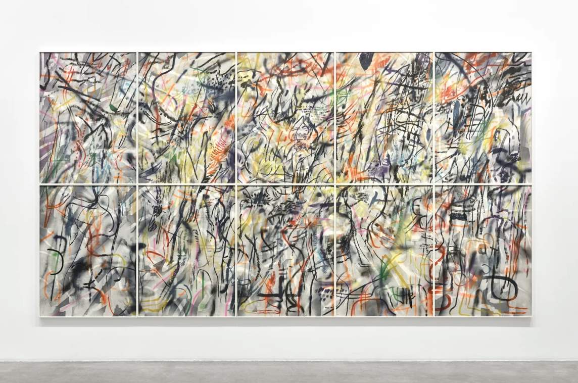 Large abstract artwork by Julie Mehretu composed of ten panels in a grid, featuring layered, colorful tangled scribbles, lines, and shapes on a white background, mounted on a gallery wall.