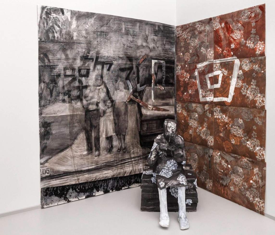 Returning is an art installation featuring a figure seated before a two large paintings making a corner backdrop on a gallery wall. On the right are brown floral patterns and on the left is impressionistic rendition of a family photo with Taiwanese characters overlaid.
