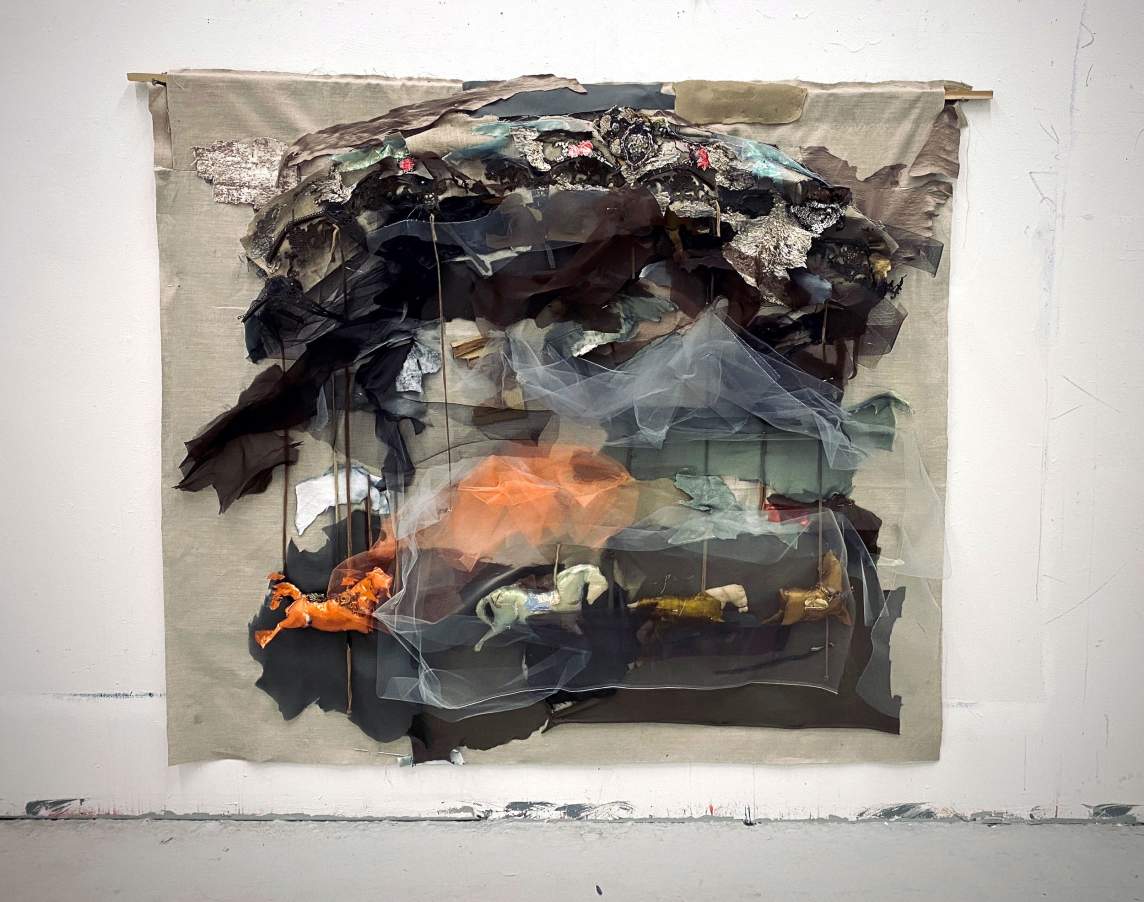 A Silent Carousel is a large wall-hung sculpture depicting a carousel, rendered in bits of fabric and thread that are pieced and stacked together.