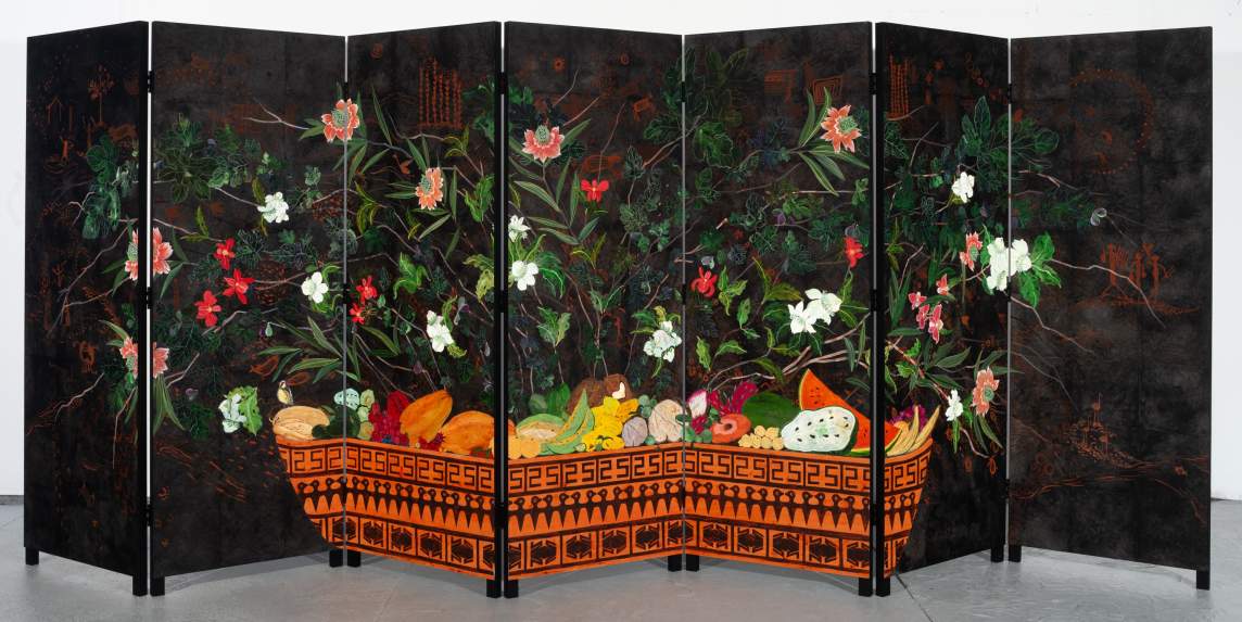 Seven black panels are joined by hinges to make a screen. A low, shallow dish in pumpkin orange decorated with black geometric designs stretches across the bottom of five of the panels. Fruit is piled in the dish under a wide spray of red and white flowers and moss- and jade-green leaves.