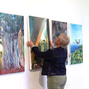 Artist Laura Kina hanging a painting on the wall of her Joan Mitchell Center studio