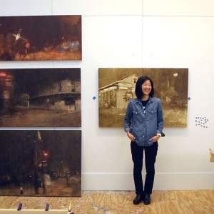 Artist Kaori Maeyama standing in her studio at the Joan Mitchell Center surrounded by oil paintings