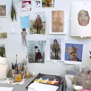 Various images pinned to wall and art-making materials in artist Ruth Owen's studio