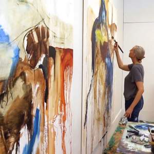 Artist Anastasia Pelias painting on a large artwork in her studio in the Joan Mitchell Center