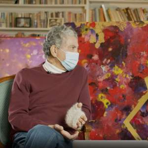 Artist Freddy Rodríguez facing interviewer Yasmeen Siddiqui in front of artwork