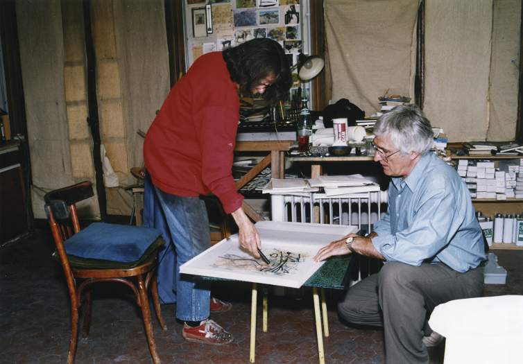 Joan Mitchell uses a lithographic crayon on mylar to experiment with the composition of a color lithograph from her 'Livre de peintre' titled Poems, while Kenneth Tyler holds the work steady