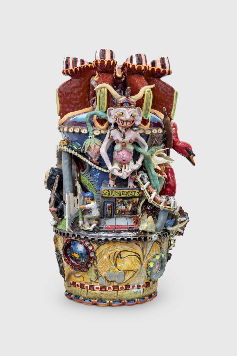Love Complicated Jug is a colorful, intricate ceramic sculpture featuring multiple detailed figures, animals, and objects, including a light demon, a red swan, a guy on a scooter, cars on a ramp and a storefront sign reading "SUBLIME".