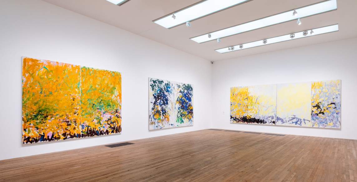 3 large abstract paintings by Joan Mitchell hang in a white gallery space.