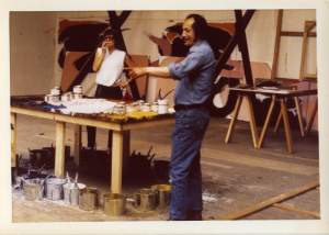 Two white people standing in an art studio