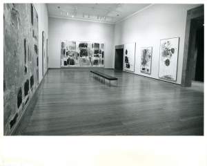 Several large abstract paintings hand on white gallery walls