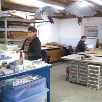 Two legacy specialists working in studio, surrounded by artwork storage furniture and lighting apparatus