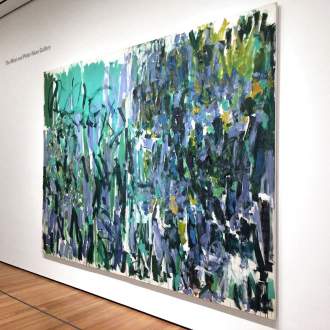 A large abstract diptych painting by Joan Mitchell installed on white wall of Museum of Modern Art.